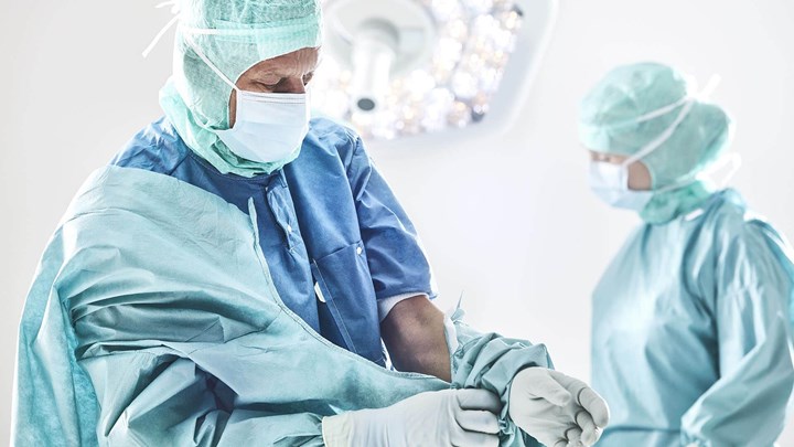 Chirurg ubierający fartuch przed operacją