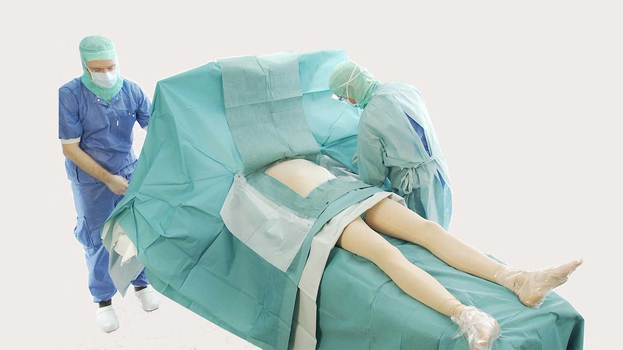 chirurg przykrywający pacjenta obłożeniem do zabiegów sercowo-naczyniowych