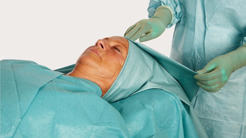 głowa kobiety przykryta obłożeniem barrier do zabiegów laryngologicznych