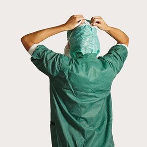 Krok 2 zakładania maski chirurgicznej z trokami  